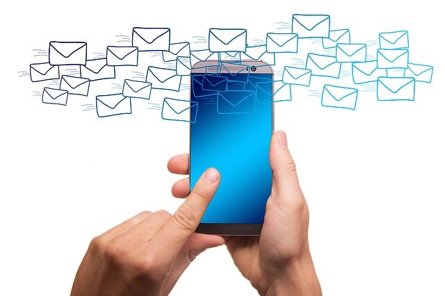 Email marketing and spam A hand with a mobile phone and envelopes