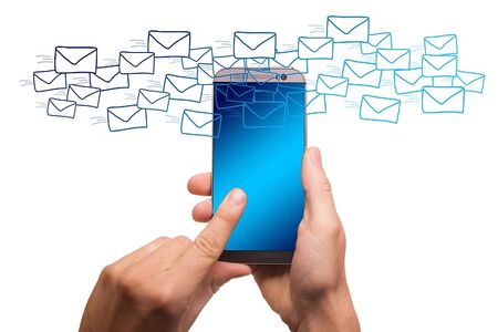 A hand with a mobile phone and envelopes