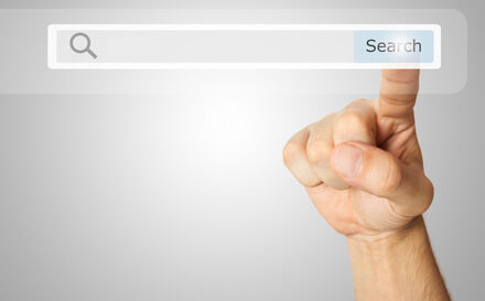 A graphic of a finger over a search bar